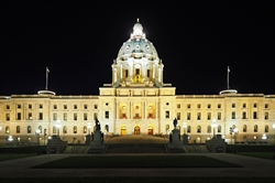 [ai] The Minnesota State Capitol building illuminated at night, showcasing its ornate architecture. The central dome is prominently lit, while statues and lampposts are visible in the foreground.
